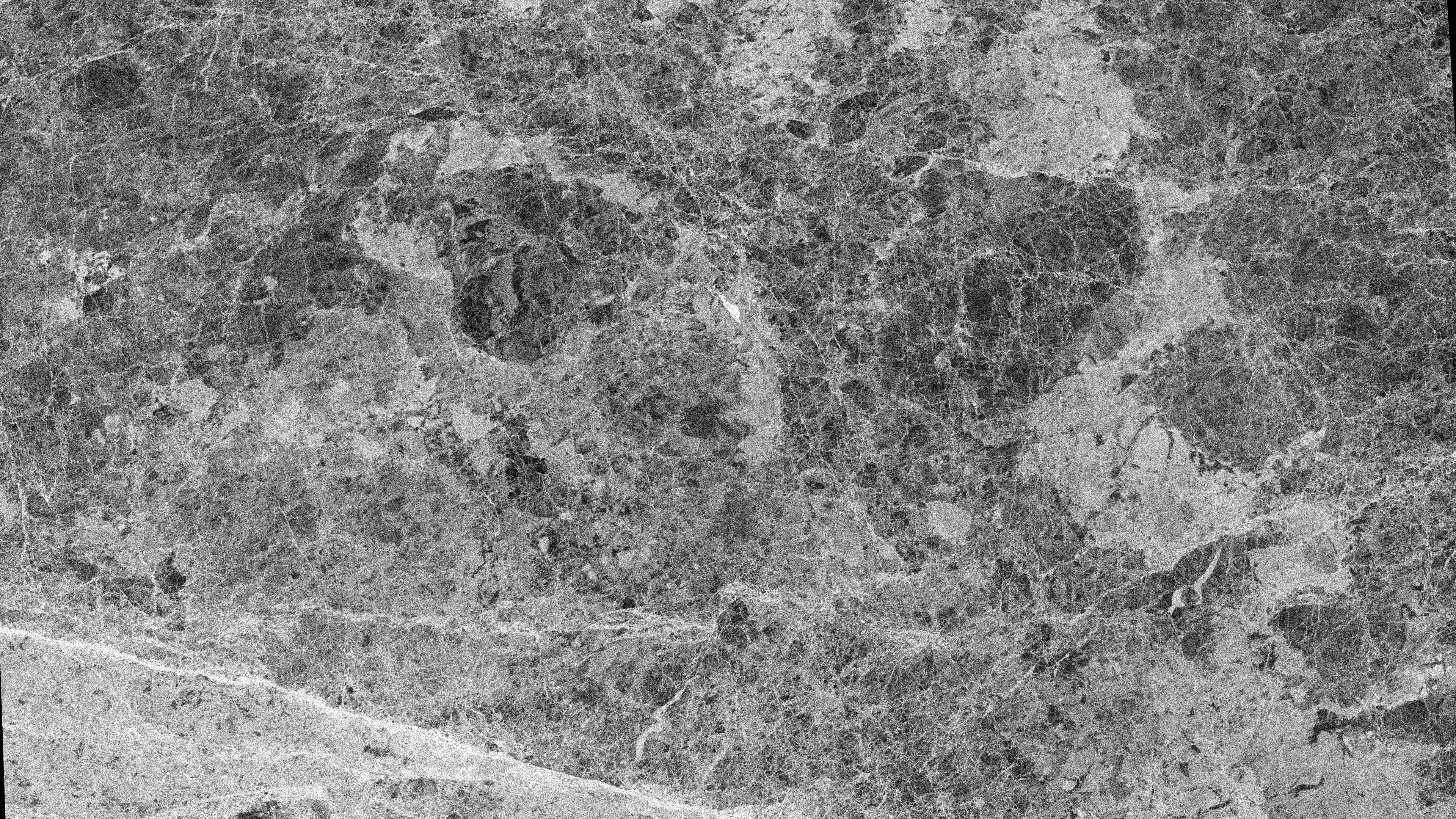 Black and white radar satellite image of Beaufort Sea pack ice with bright ridges, smooth floes, and dark open leads.