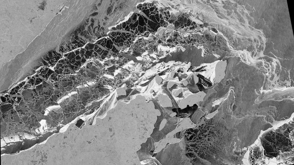 Black and white radar satellite image of Lake Superior ice around the Apostle Islands, showing textured ice fields and dark water.